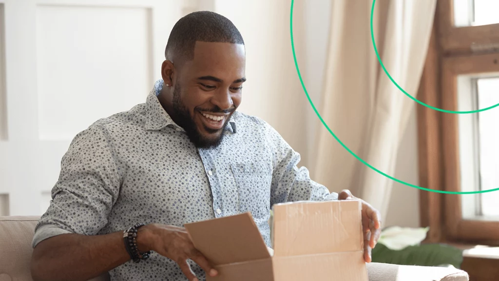 Homem abrindo uma encomenda com expressão feliz, representando a alegria de ter um sistema de gestão para encomendas