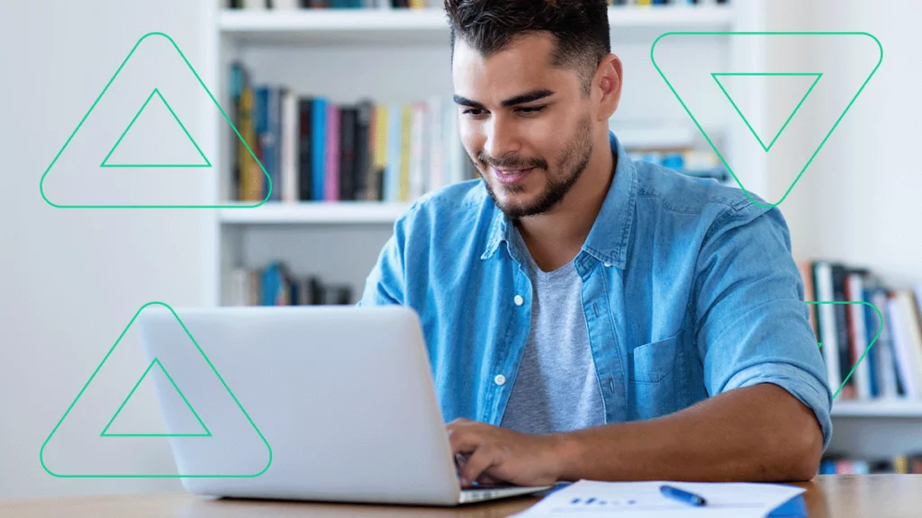 Empreendedor escrevendo e-mails marketing no seu notebook e sorrindo