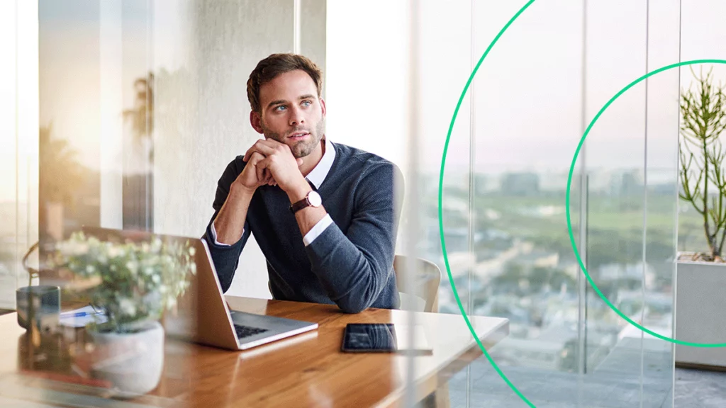 Empreendedor em seu escritório, com expressão de reflexão, pensando se é possível empreender na crise