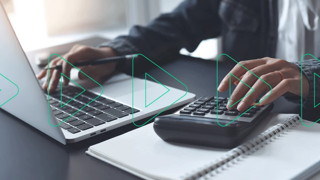 Close-up de uma pessoa usando uma calculadora e um laptop para calcular os gastos da empresa