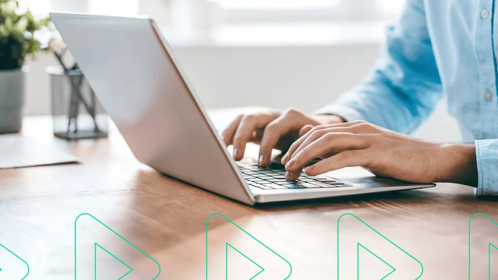 Pessoa digitando em um laptop, pesquisando sobre quem deve emitir a Nota Fiscal Eletrônica