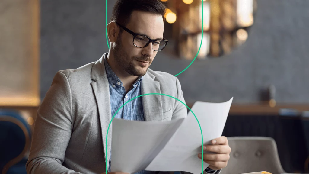 Empresário olhando concentrado para o papel em sua mão, tentando entender as regras para o CEST 2017