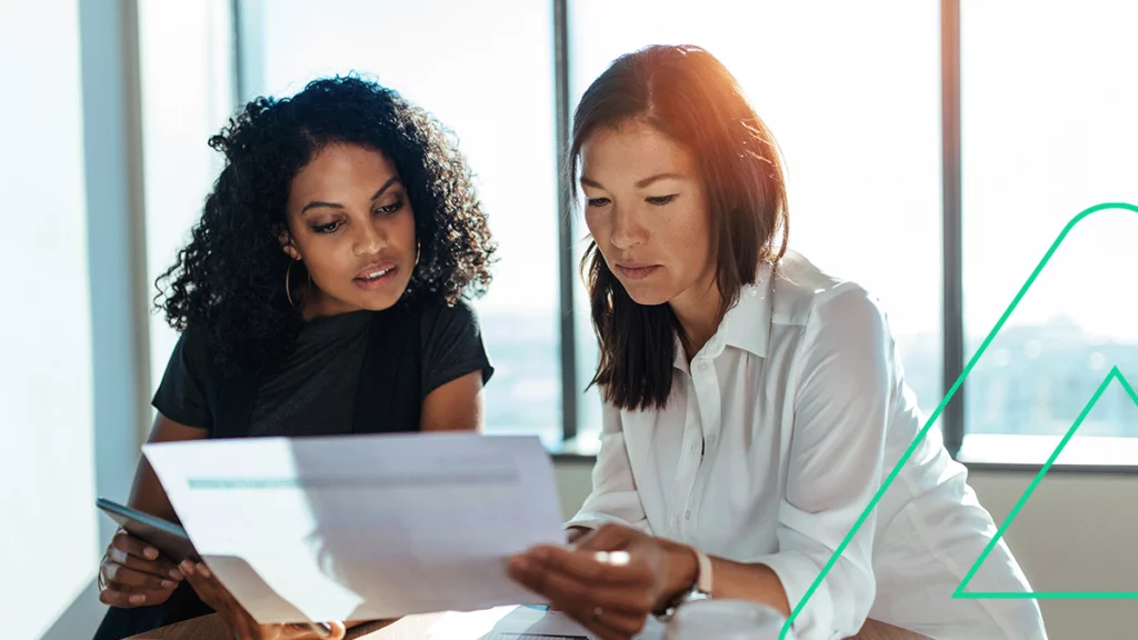 Uma mulher mostrando a tabela CFOP para a outra e explicando o que é
