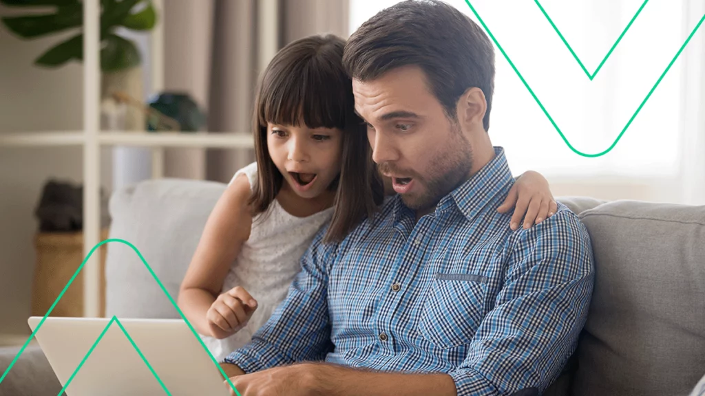 Pai com uma criança pequena assitindo algo interessante no notebook