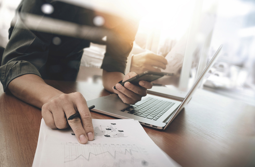 Empreendedor conferindo relatórios e calculando o lucro da sua empresa no seu telefone