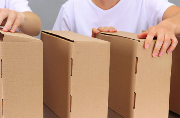 Empreendedor conferindo várias embalagens de papelão, para decidir qual a melhor para seu e-commerce