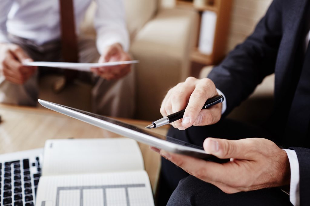 Homem apresentando o e-social para um empreendedor, em seu tablet