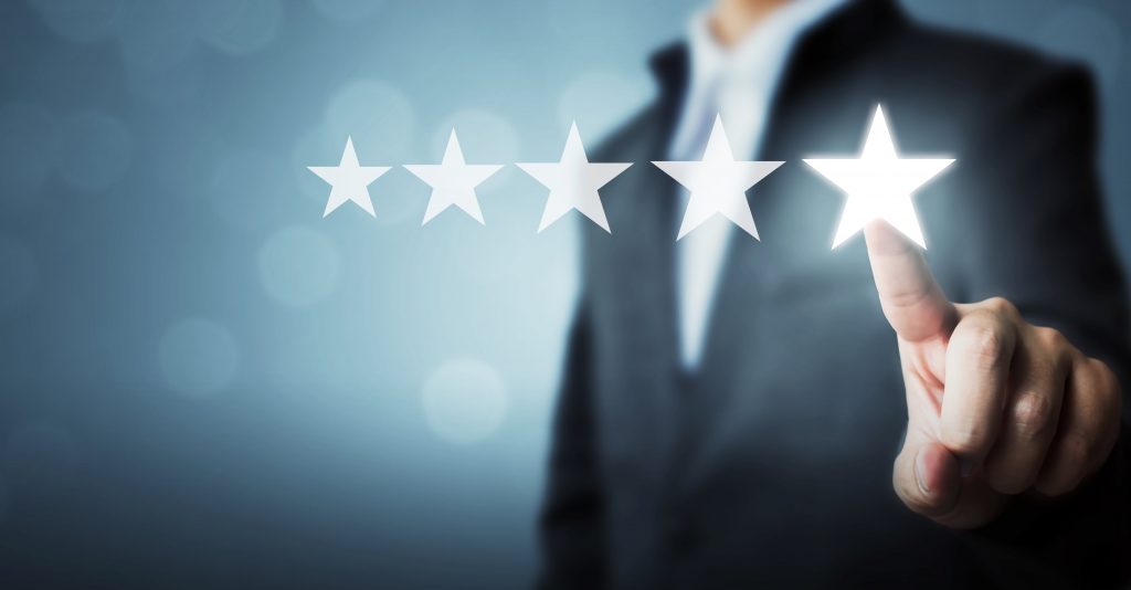 Homem com roupa forma tocando na quinta estrela que flutua na sua frente, representando a nota máxima avaliada no Customer Success