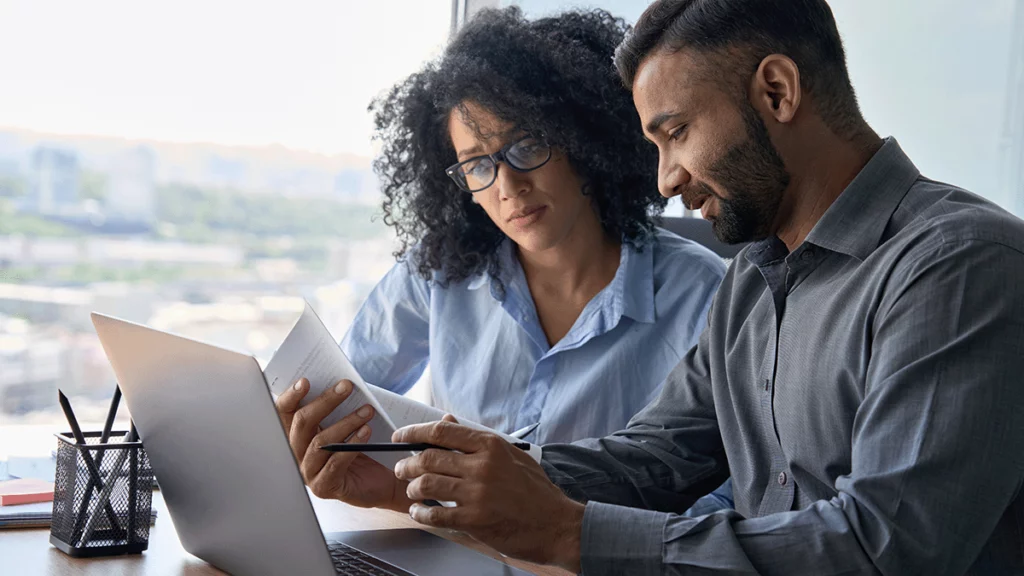 Dois empreendedores analisando os relatórios de KPIs de vendas da empresa