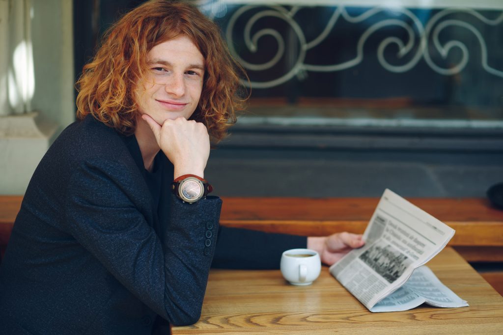 Microempreendedor Individual sorrindo enquanto lê as mudanças para o MEI no jornal