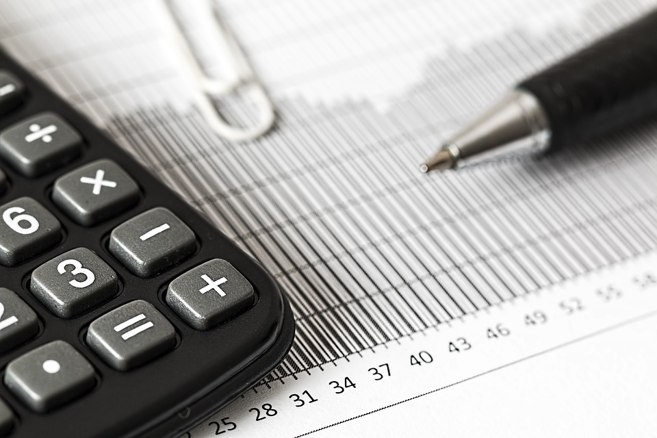 Close-up de um relatório, uma caneta e uma calculadora, definindo o capital de giro do negócio