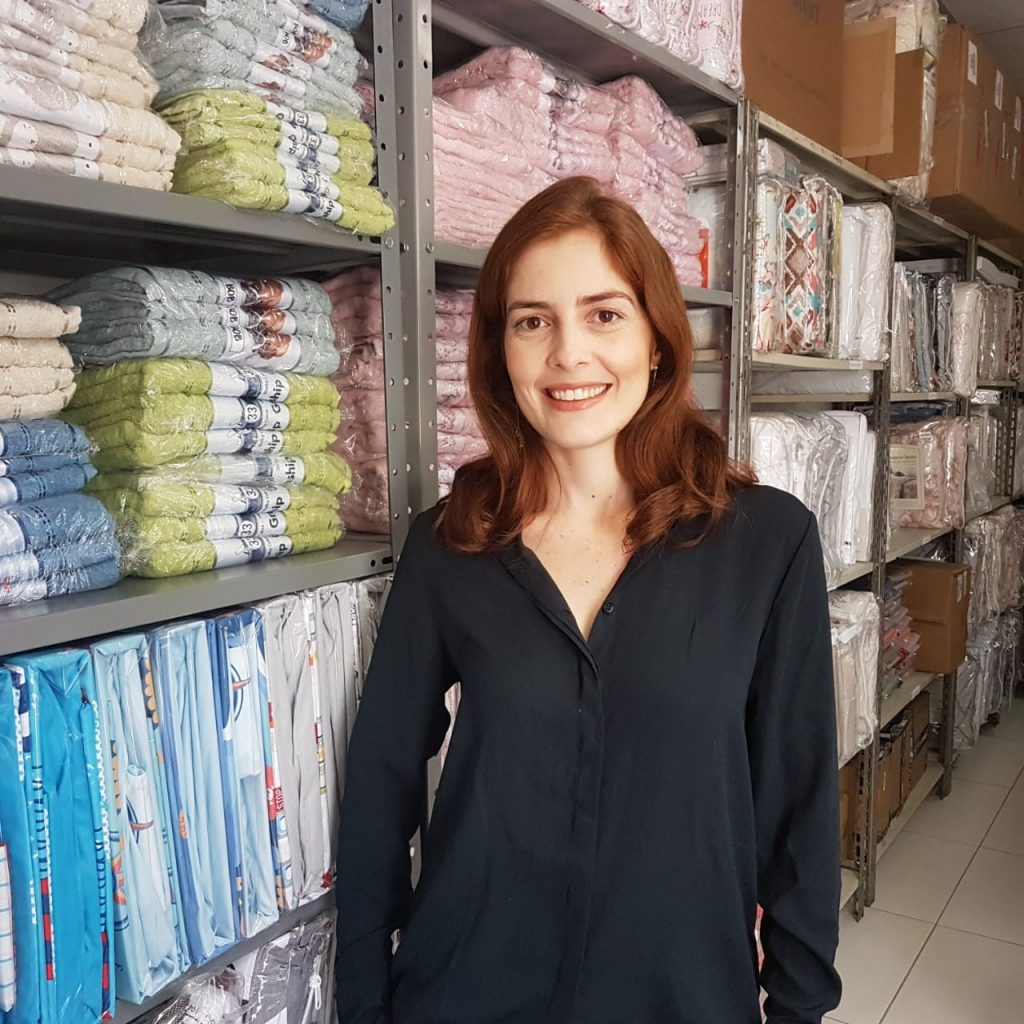 Na frente de uma prateleira em sua loja, Luiza, dona da Outlet Enxoval, caso de sucesso do Bling