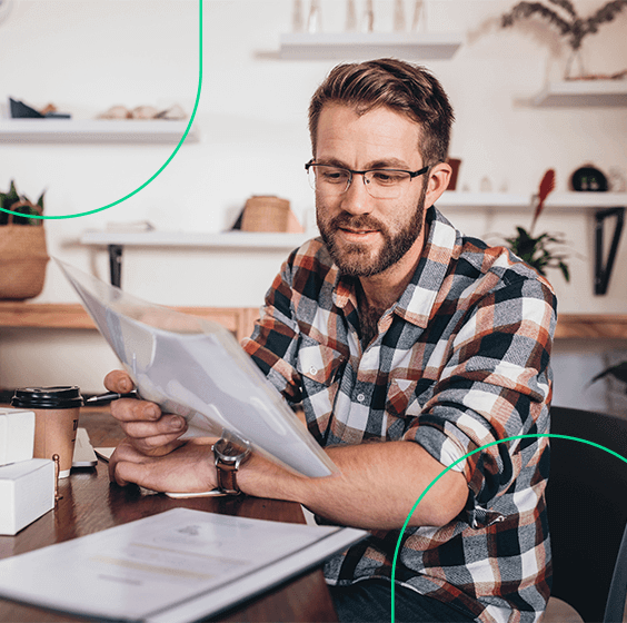 Empreendedor analisando documentos, livros e papéis sobre sua mesa