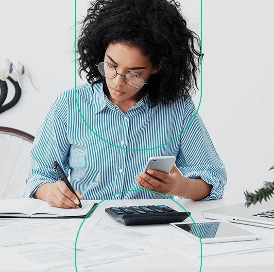 Empreendedora usando uma calculadora e seu celular para fazer anotações sobre o payback em sua agenda
