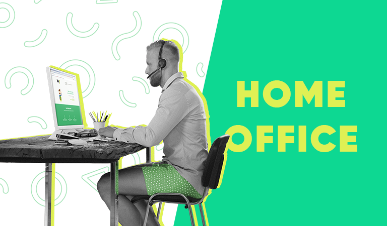 Homem sentado em sua mesa de computador em casa, vestindo um short casual, com as palavras "Home Office" ao seu lado
