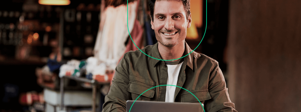 Empreendedor sorrindo, contente com o sistema de gestão em seu computador