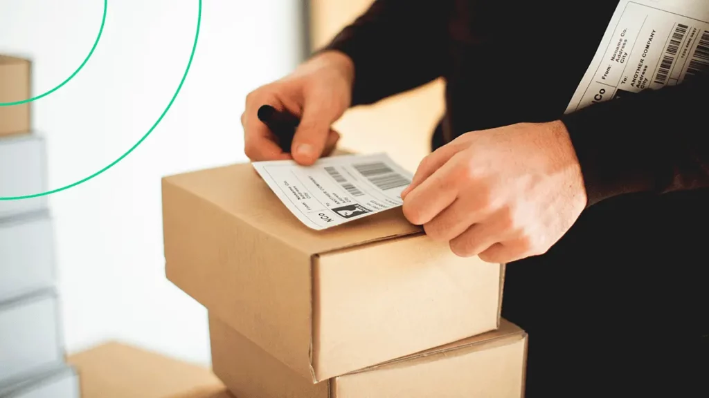Empreendedor colando etiquetas de logística para transportar suas vendas