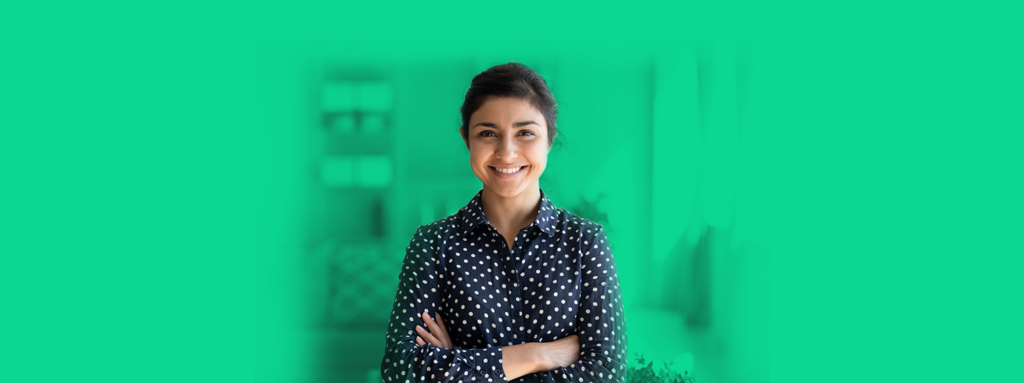 Mulher sorrindo para a câmera com os braços cruzados, representando um cliente VIP