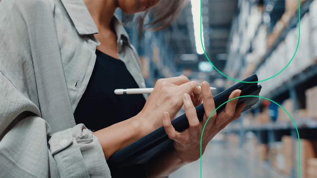 Empreendedora no depósito da empresa, fazendo o controle de estoque em um tablet