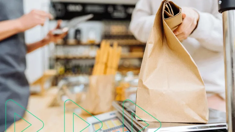 Caixa de loja atendendo consumidora que está pesando seu produto na balança