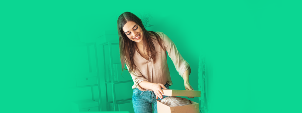 Empreendedora sorrindo ao separar as encomendas da sua loja virtual, feliz com seus lucros