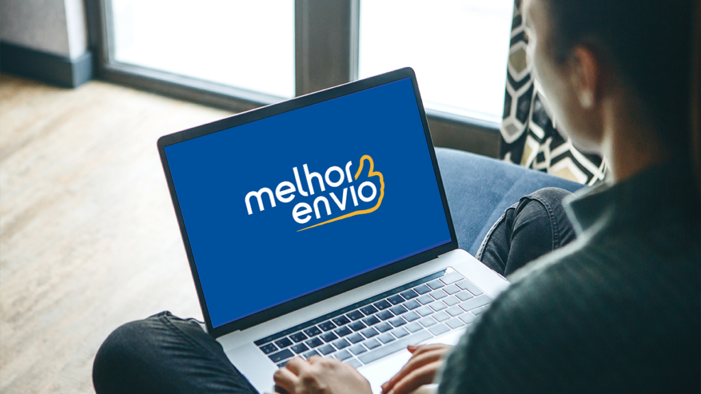 Pessoa sentada com um notebook no colo, com o logotipo do Melhor Envio na tela
