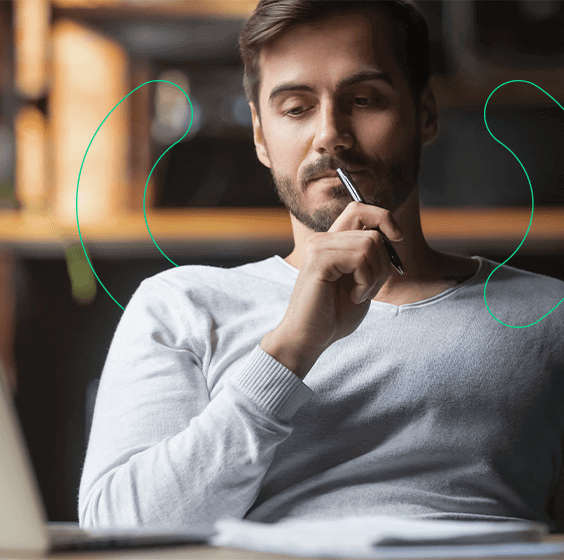 Empreendedor com caneta na mão, pensativo sobre como emitir nota fiscal para vendas online