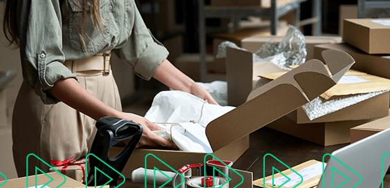 Empreendedora em um depósito, preparando as encomendas para enviar no seu clube de assinatura e-commerce